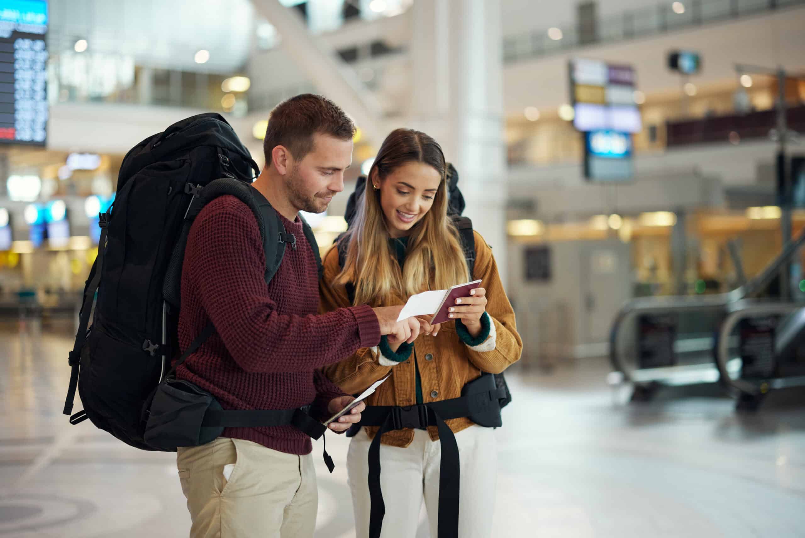 Woman and man looking at device in airport