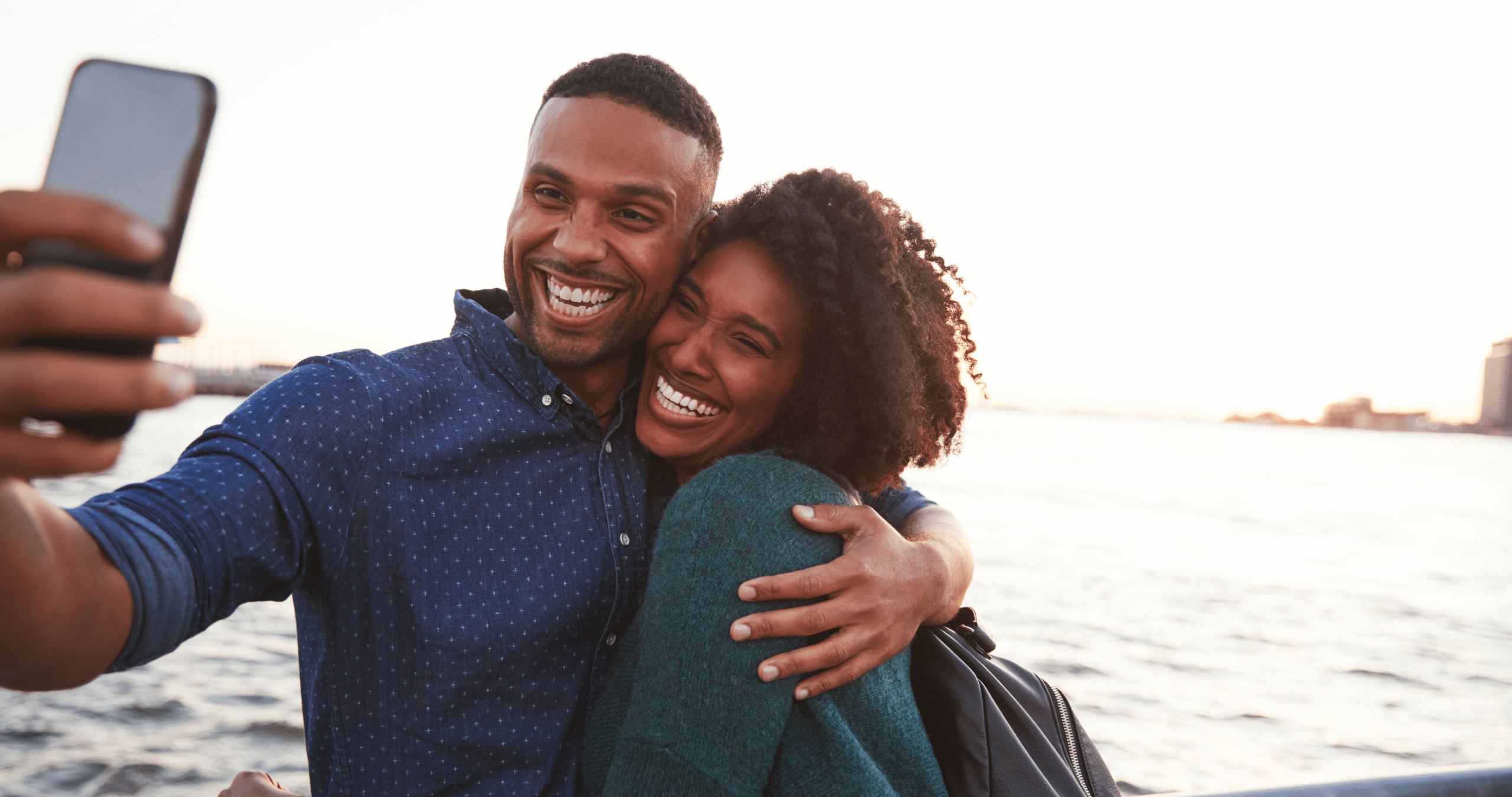 Couple on the beach taking selfie and smiling